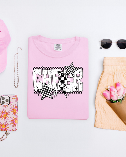 Pink t-shirt with 'CHEER' design on a white surface with accessories.