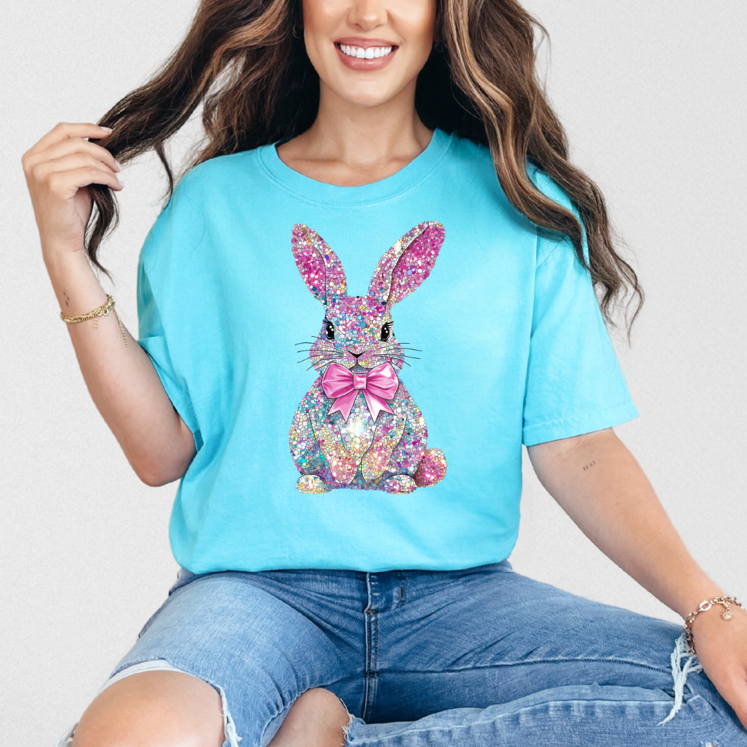 Woman wearing a blue t-shirt with a colorful bunny design on a plain background