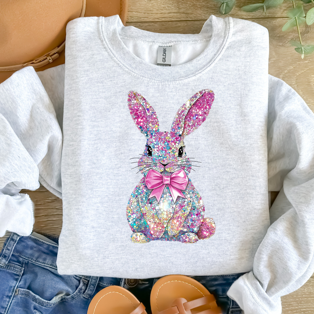White sweatshirt with a colorful bunny design on a wooden surface