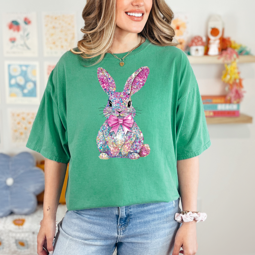 Person wearing a green t-shirt with a colorful bunny design