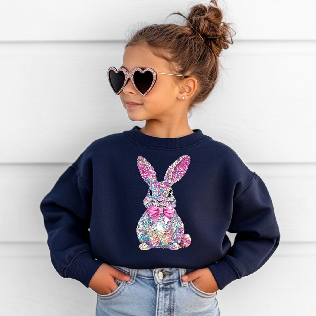 Child wearing a navy blue sweatshirt with a colorful bunny design, 