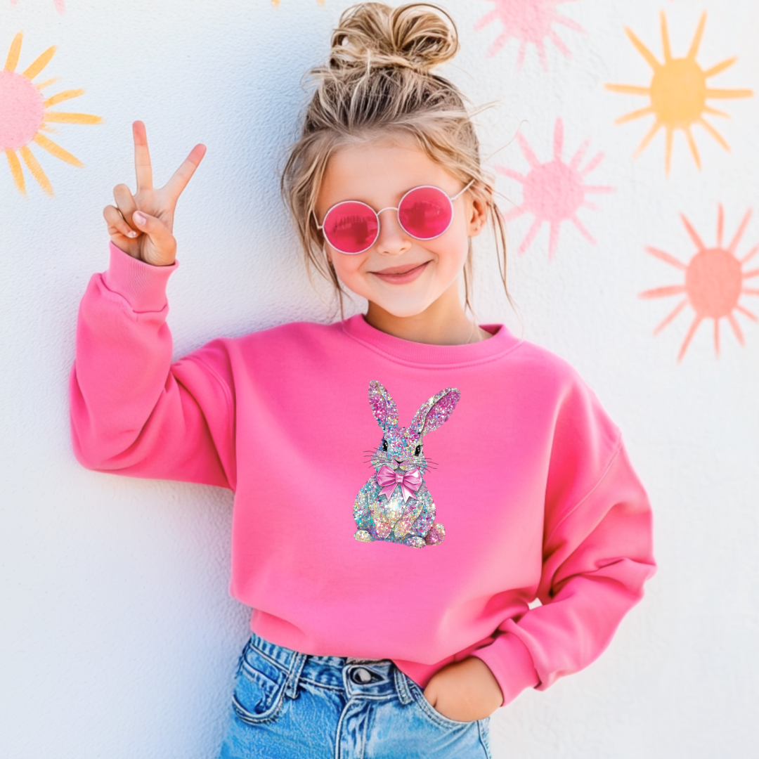 Child wearing a pink sweatshirt with a colorful bunny design, 