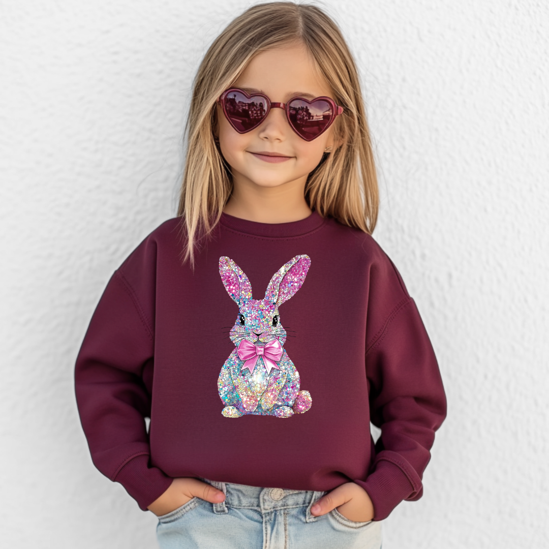 Child wearing a maroon sweatshirt with a colorful bunny design 